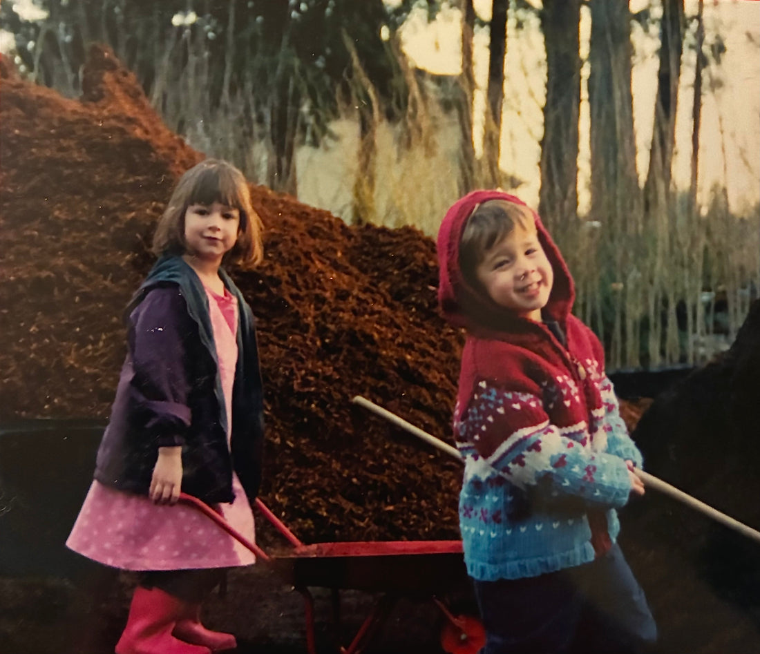 two kids shoveling bark